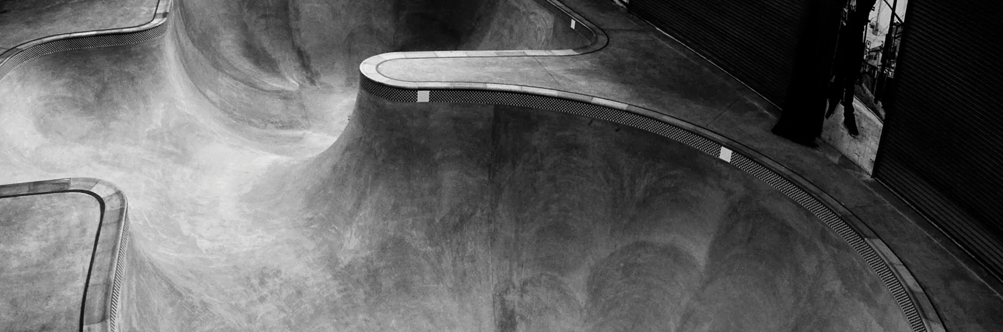 Black and white photo of an empty concrete skate bowl