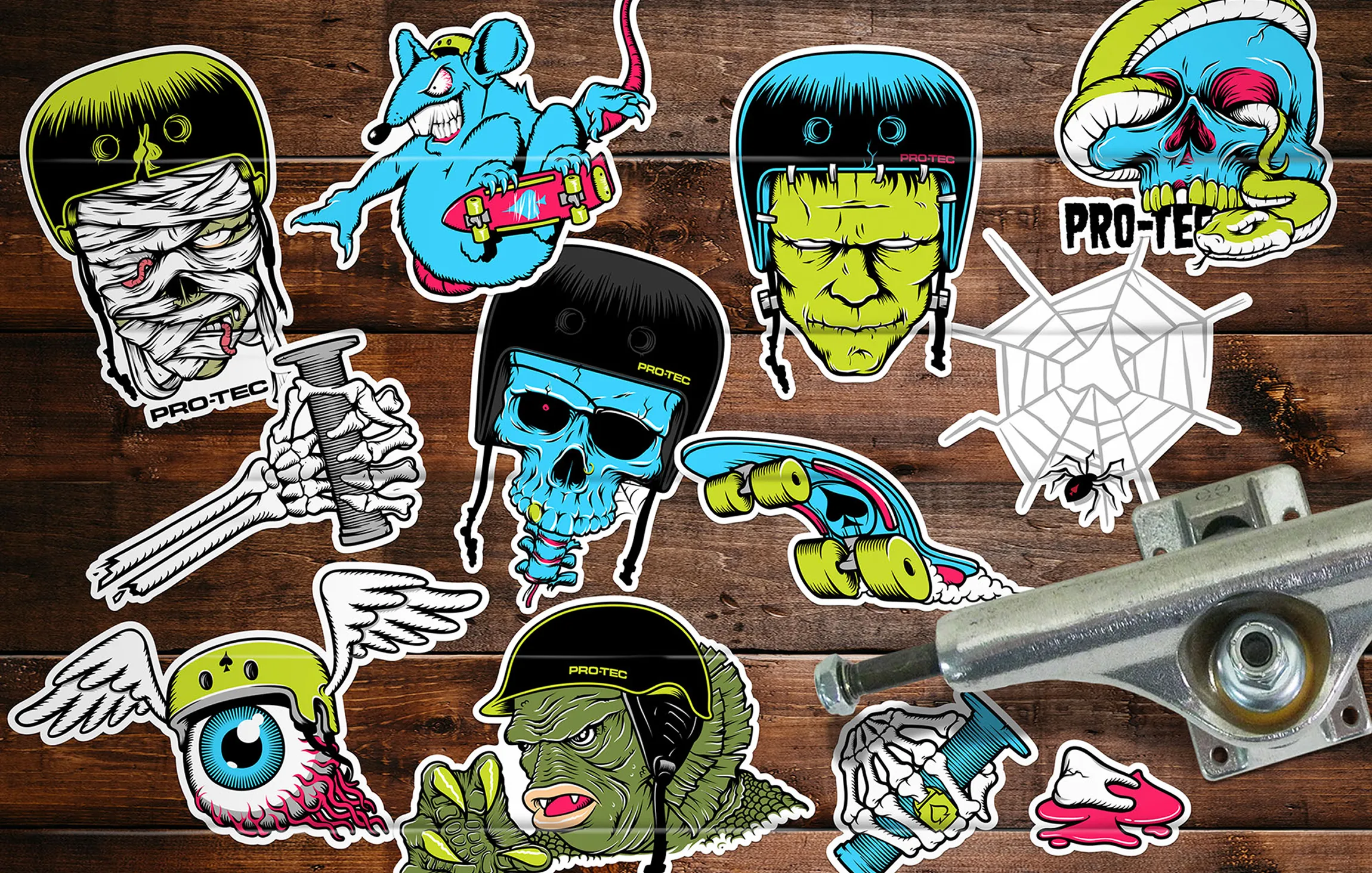 Pro-Tec monster helmet stickers spread on a wooden board with a skateboard truck